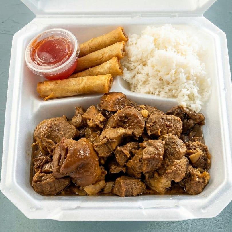 A takeout container with beef adobo, white rice, three lumpia, and a side of sweet chili sauce.